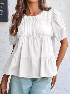 White maternity blouse with puff sleeves, ruffled tiers, and smocked bodice detail.