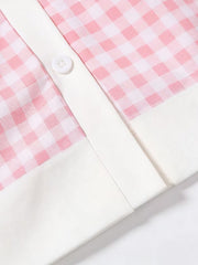 Pink gingham toddler dress with white trim and button detail.