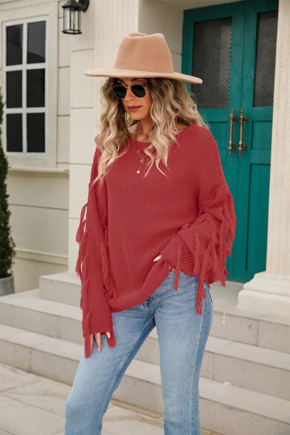Rust acrylic knit sweater with fringe sleeves and a relaxed fit.