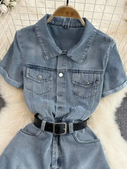 Light wash denim romper with short sleeves, collar, button front, chest pockets, and black belt.