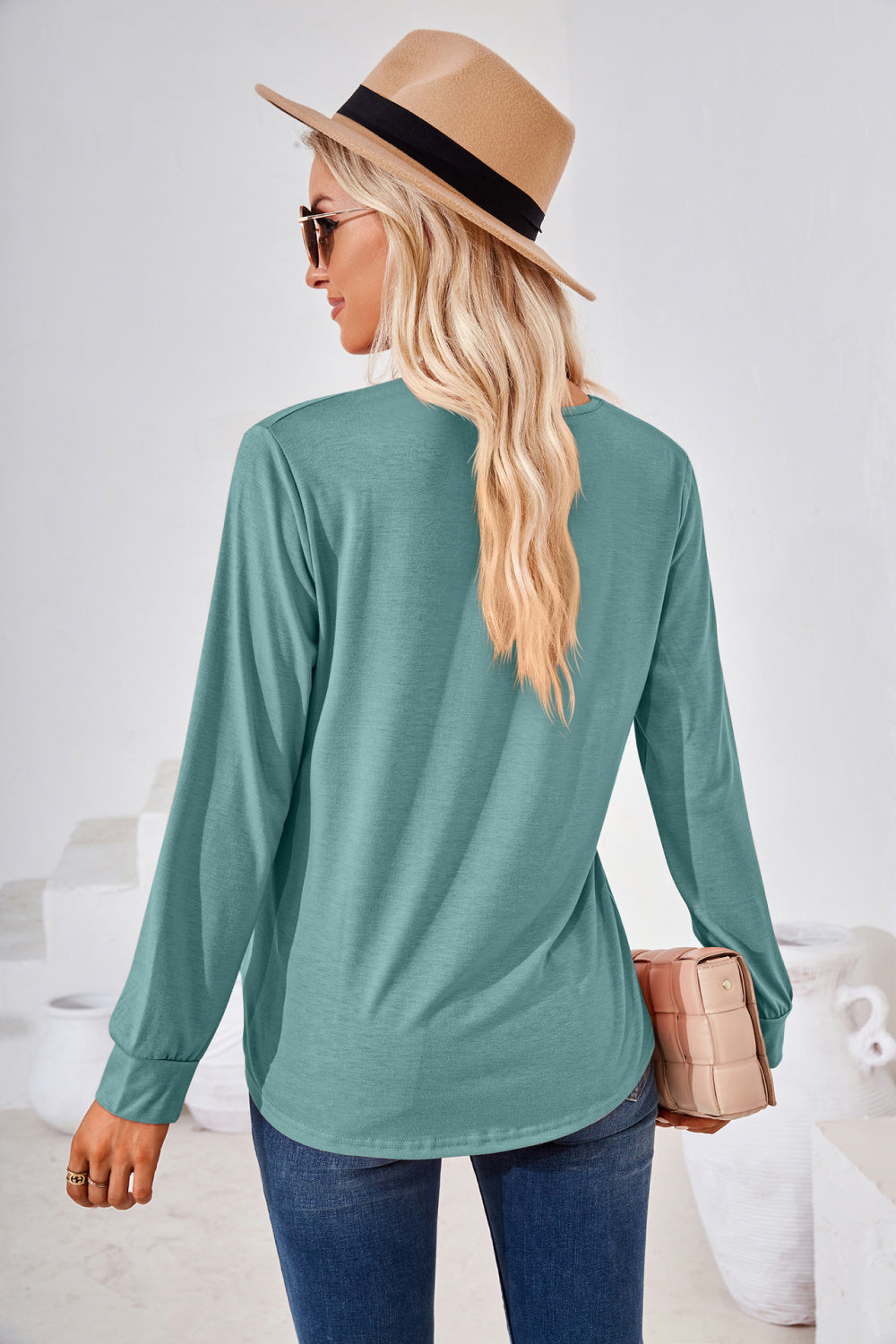 Teal long sleeve jersey top with gathered square neckline and curved hem.