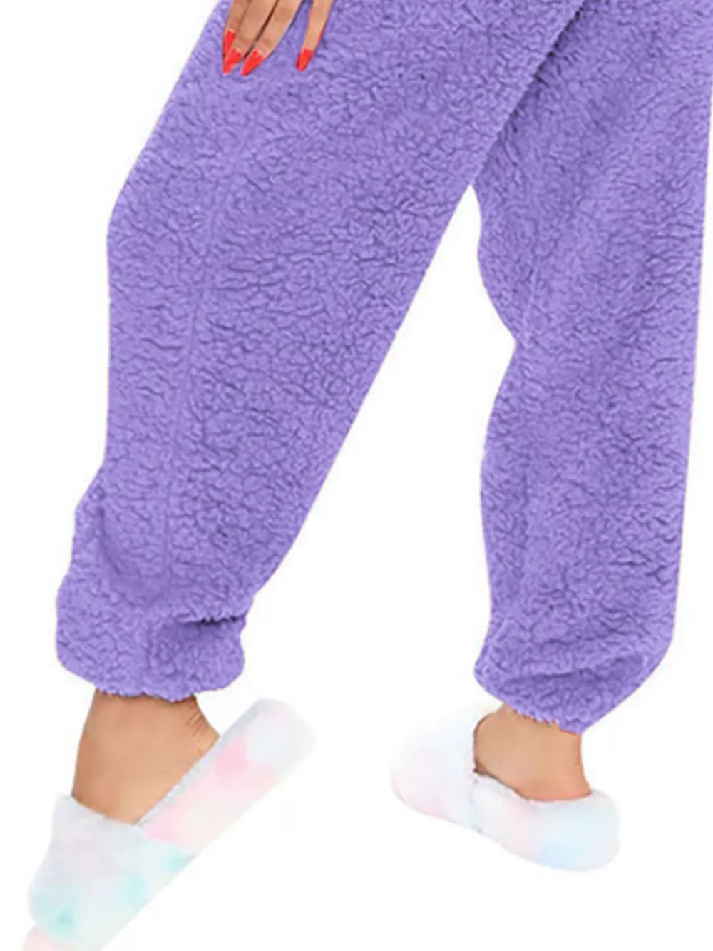Purple fleece romper with open back detail, worn with tie-dye slippers.