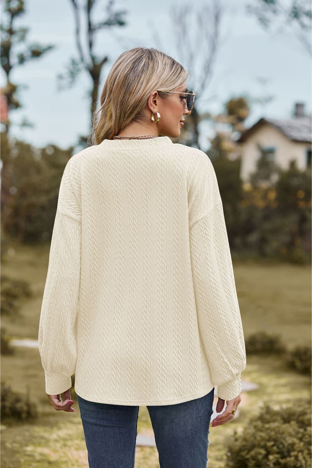 Ivory textured cable knit V-neck sweater with long balloon sleeves.