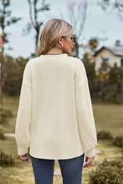 Ivory textured cable knit V-neck sweater with long balloon sleeves.