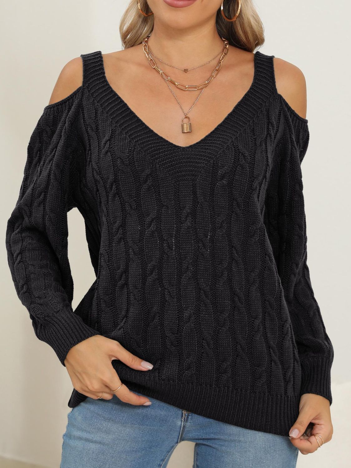 Black cable knit cold shoulder sweater with V-neck and balloon sleeves.