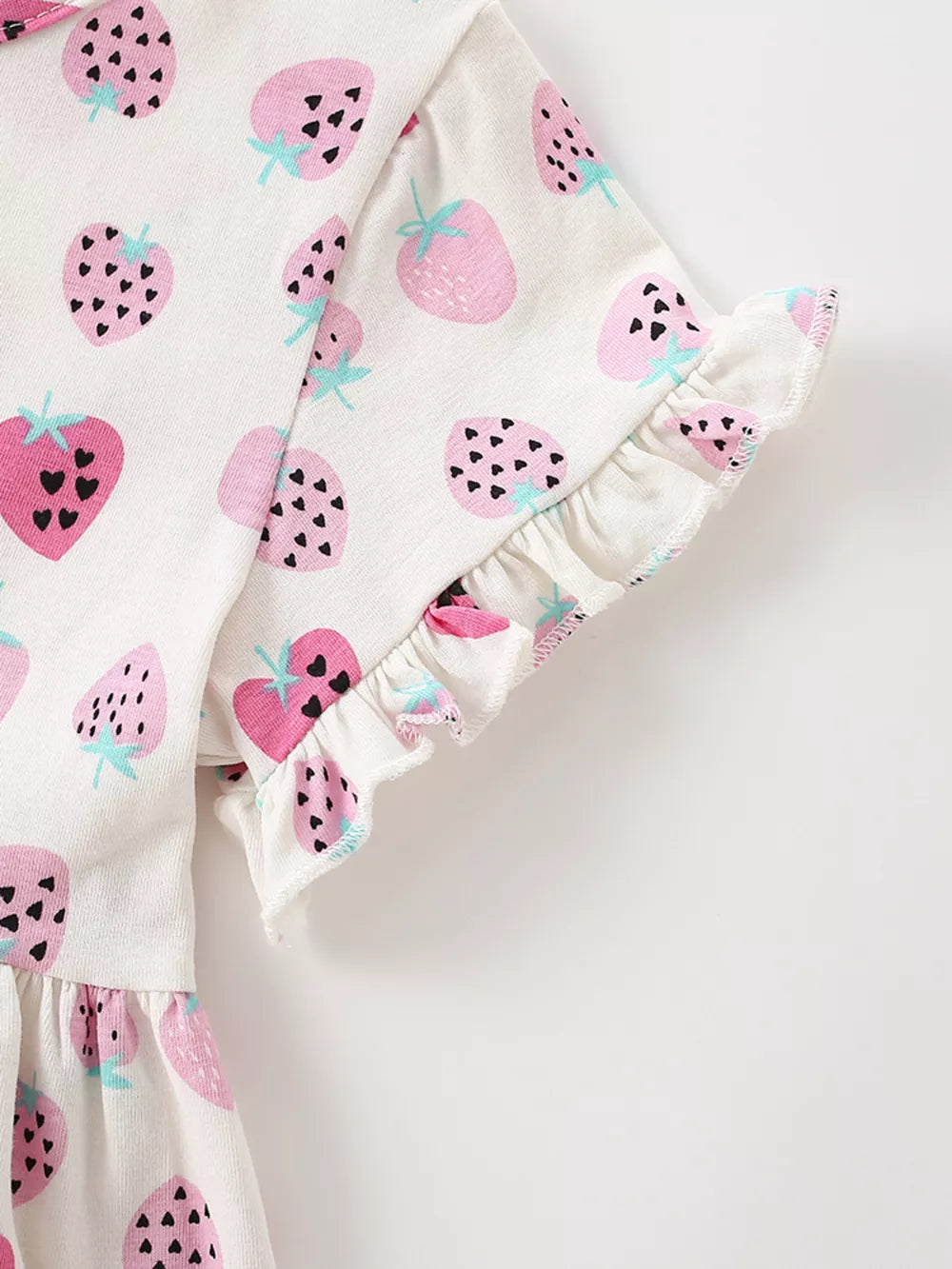 Toddler dress with strawberry print and ruffled sleeves in white cotton.