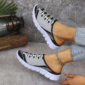 Black and white knit slip-on sneakers with white laces and soles.
