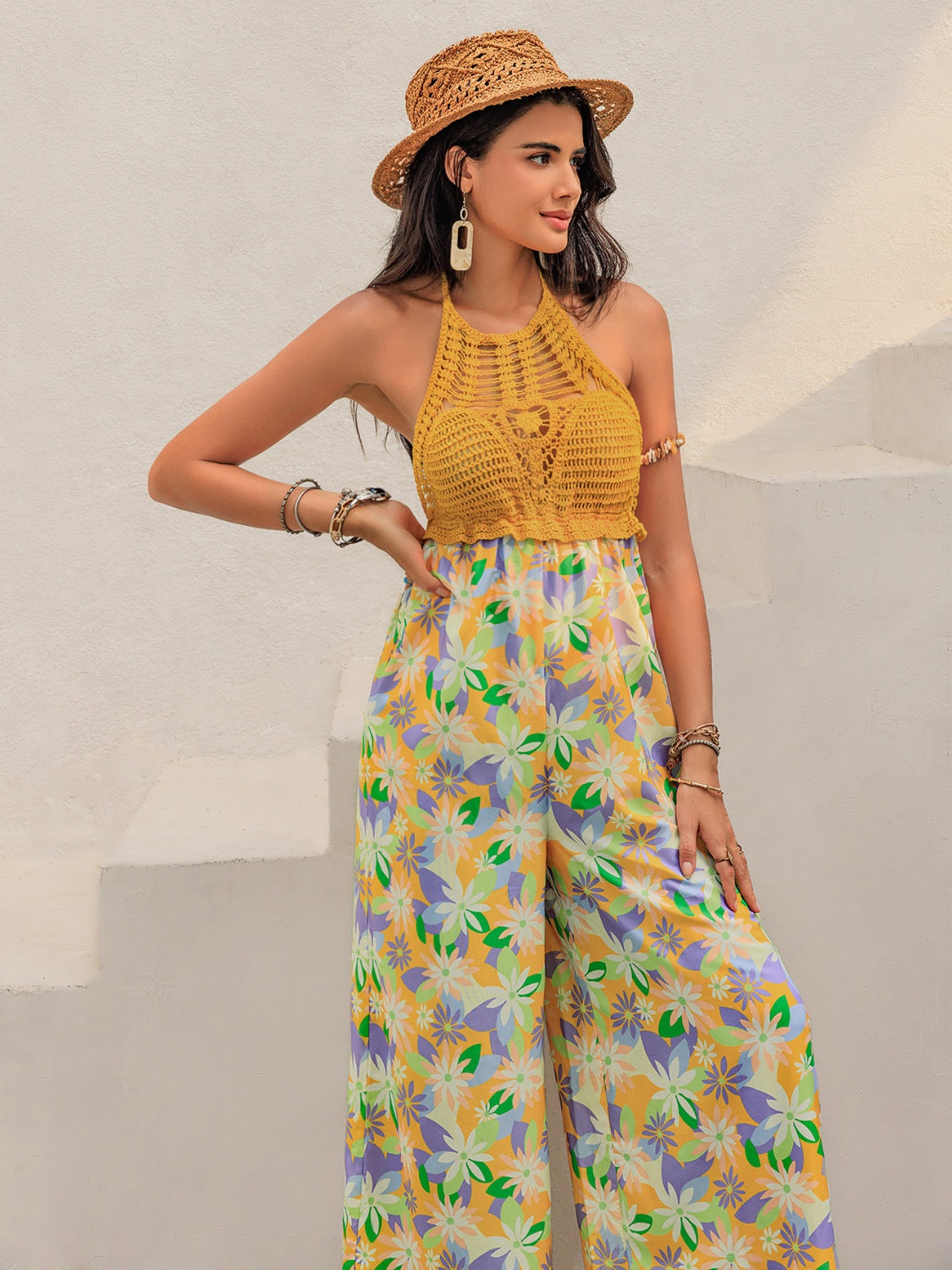 Gold crochet halter jumpsuit with a floral print palazzo pant and wide legs.