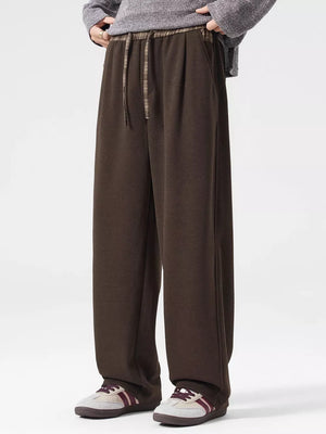 Brown loose-fit men's sweatpants with drawstring waist and plaid detail.