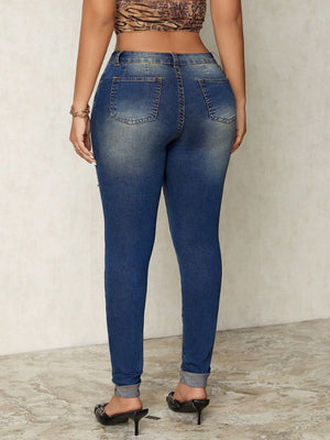 Distressed skinny jeans in medium wash denim with zip details and rolled cuffs.