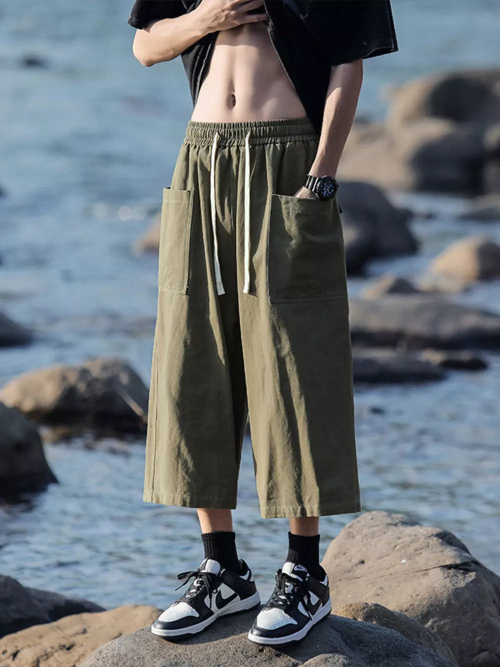 Green relaxed fit cropped sweatpants with drawstring waist and large front pockets.