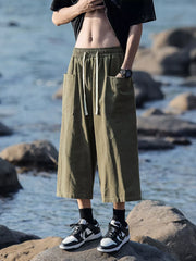 Green relaxed fit cropped sweatpants with drawstring waist and large front pockets.