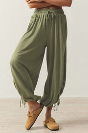 Matcha green balloon trousers with gathered ankle ties and a drawstring waist.