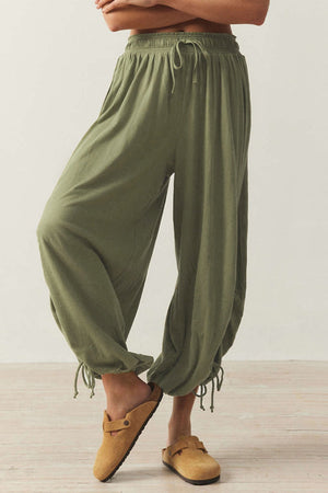 Matcha green balloon trousers with gathered ankle ties and a drawstring waist.