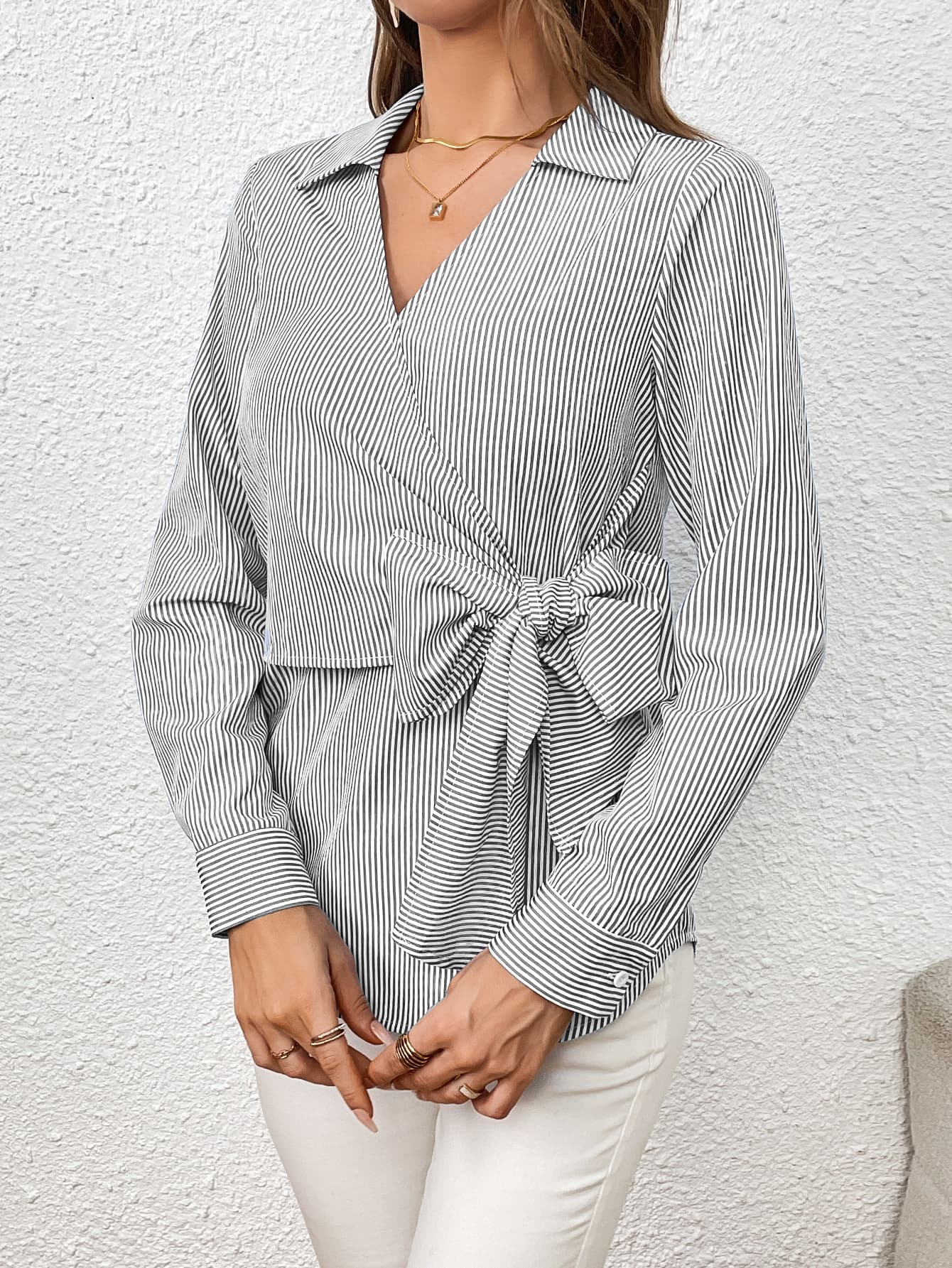 Gray striped wrap blouse with a large bow detail and V-neck.