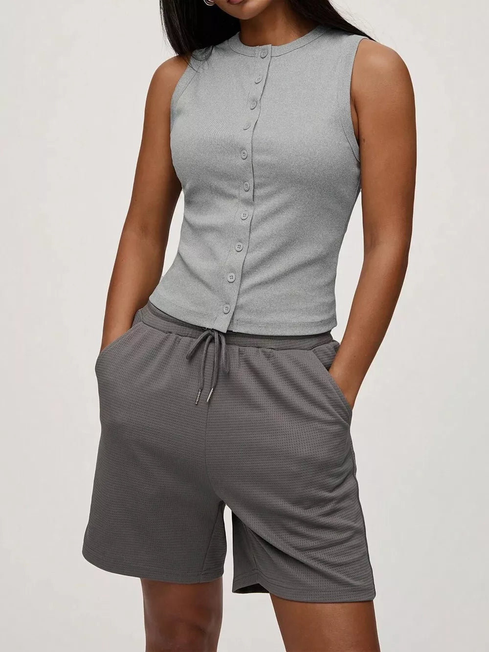 Light gray ribbed button-front tank top with a crew neck and sleeveless design.