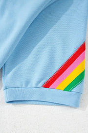 Light blue activewear shorts with rainbow stripe detail on the side.