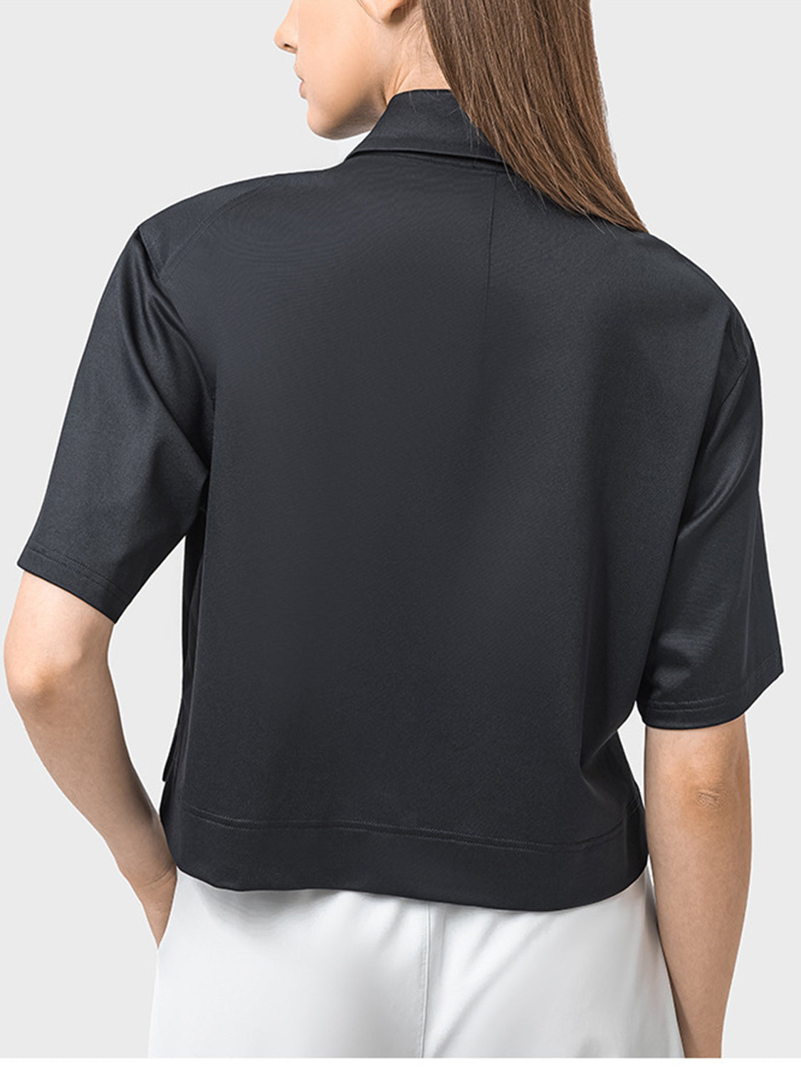Black cropped polo sportif top with short sleeves and a collar.
