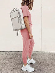 Pink cotton loungewear set with round neck top and jogger pants, styled with a backpack.