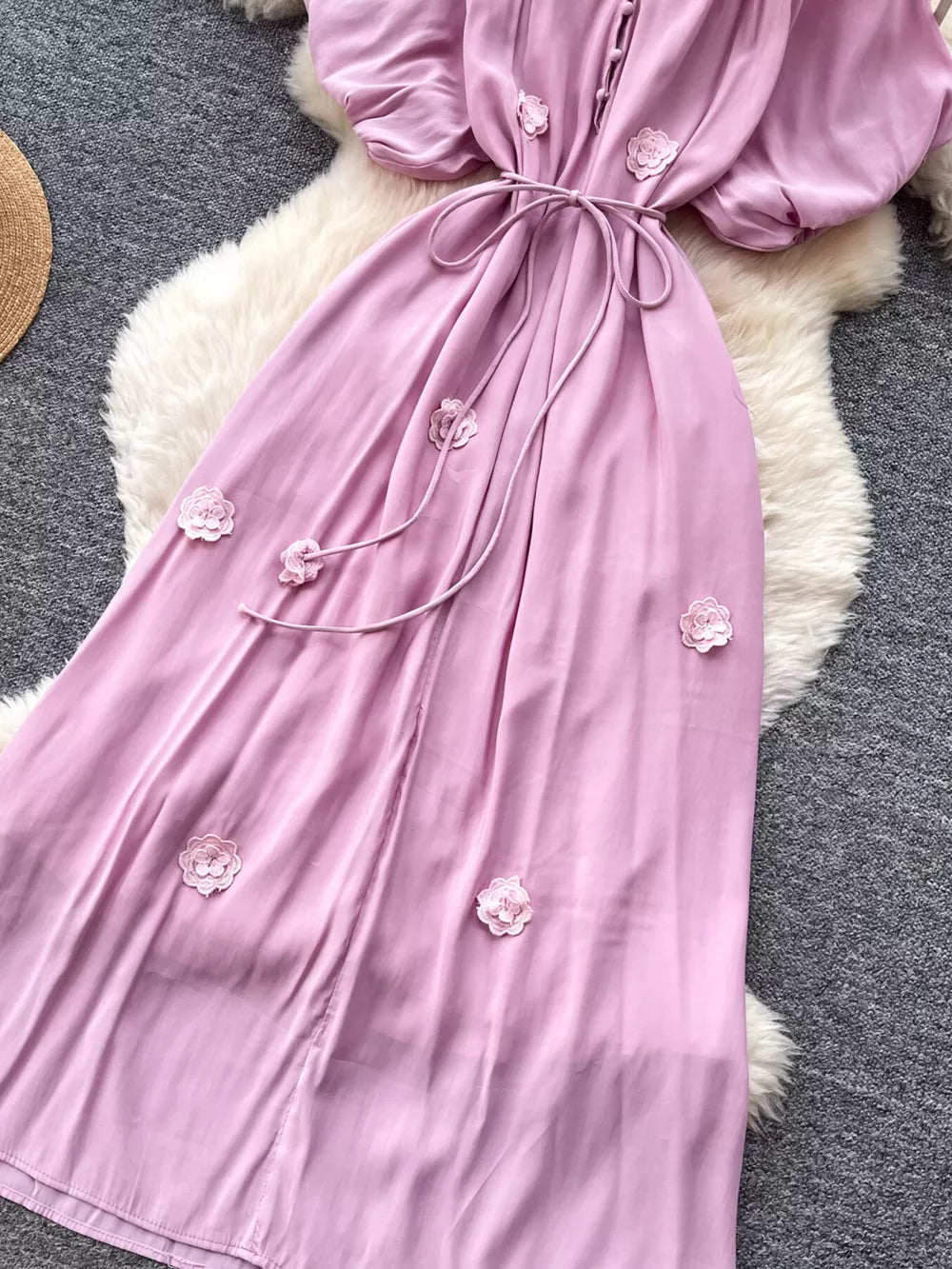 Purple floral maxi dress with puff sleeves, tie waist, and button front.