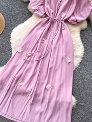 Purple floral maxi dress with puff sleeves, tie waist, and button front.