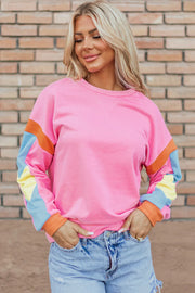 Colorblock sleeve crewneck sweatshirt in fuchsia pink with orange, blue, and yellow colorblock detail on sleeves.