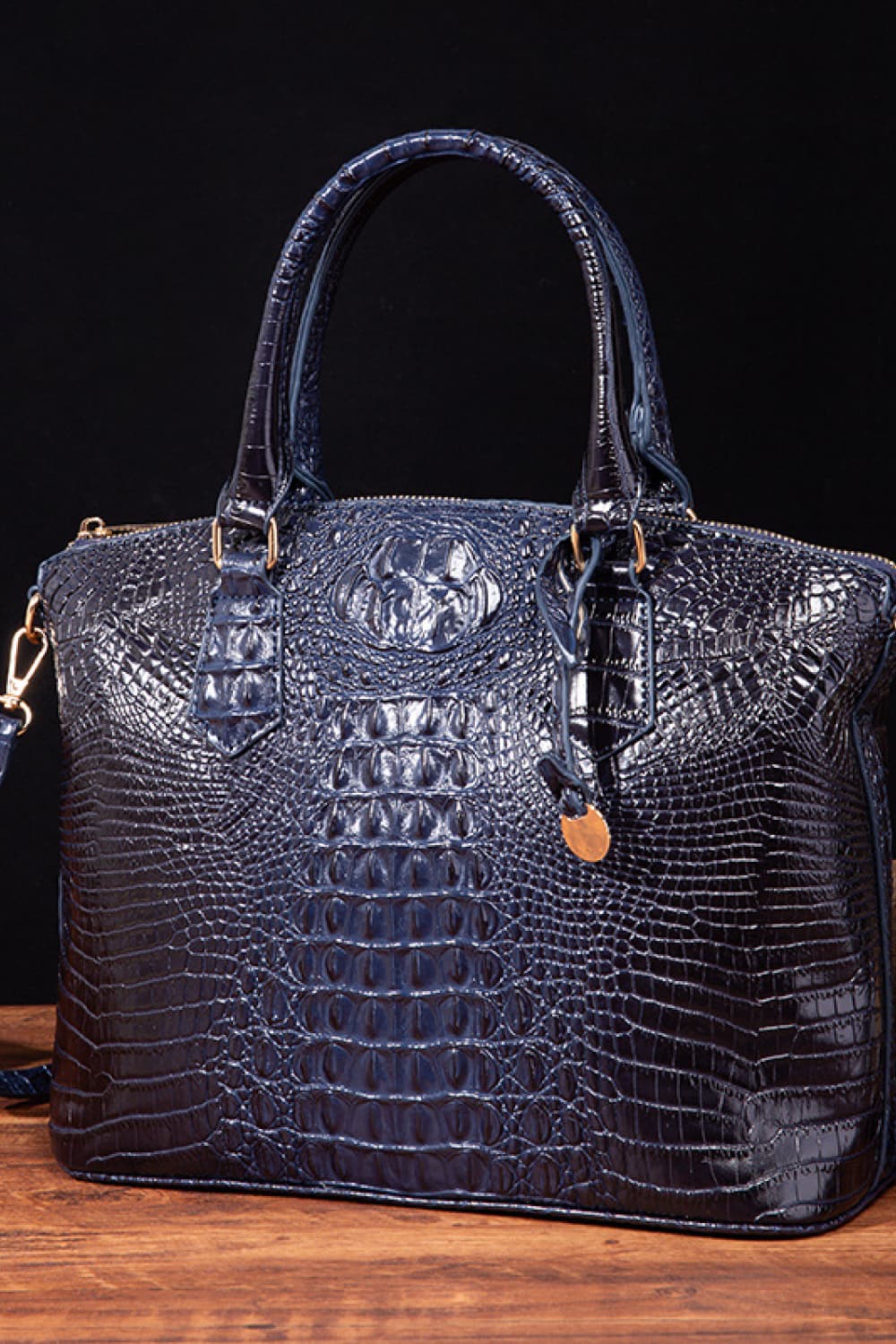 Dark Blue crocodile embossed satchel bag with top handles and shoulder strap detail.