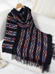 Black hooded knit cape with colorful diamond pattern and fringe detail