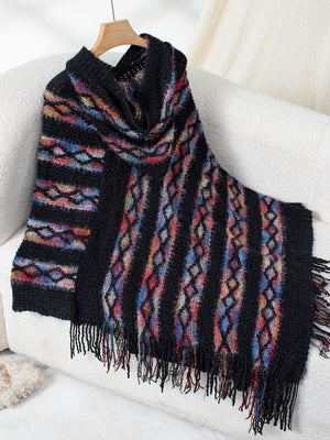 Black hooded knit cape with colorful diamond pattern and fringe detail