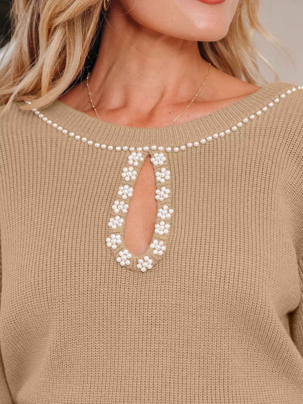 Tan ribbed sweater dress with pearl-adorned keyhole neckline and shoulder trim.