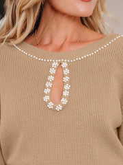 Tan ribbed sweater dress with pearl-adorned keyhole neckline and shoulder trim.