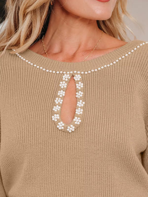 Tan ribbed sweater dress with pearl-adorned keyhole neckline and shoulder trim.