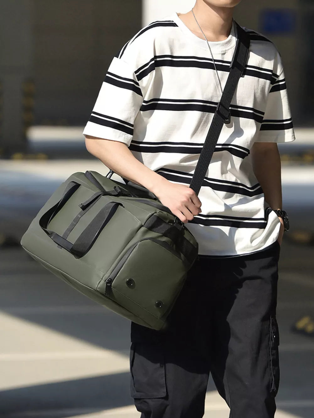 Green Oxford cloth travel bag with black handles and strap, side zip pocket.