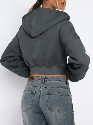 Dark gray cropped zip-up hoodie with ribbed hem and a raw edge detail.