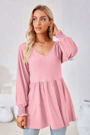 Pink textured babydoll blouse with V-neck and smocked cuffs