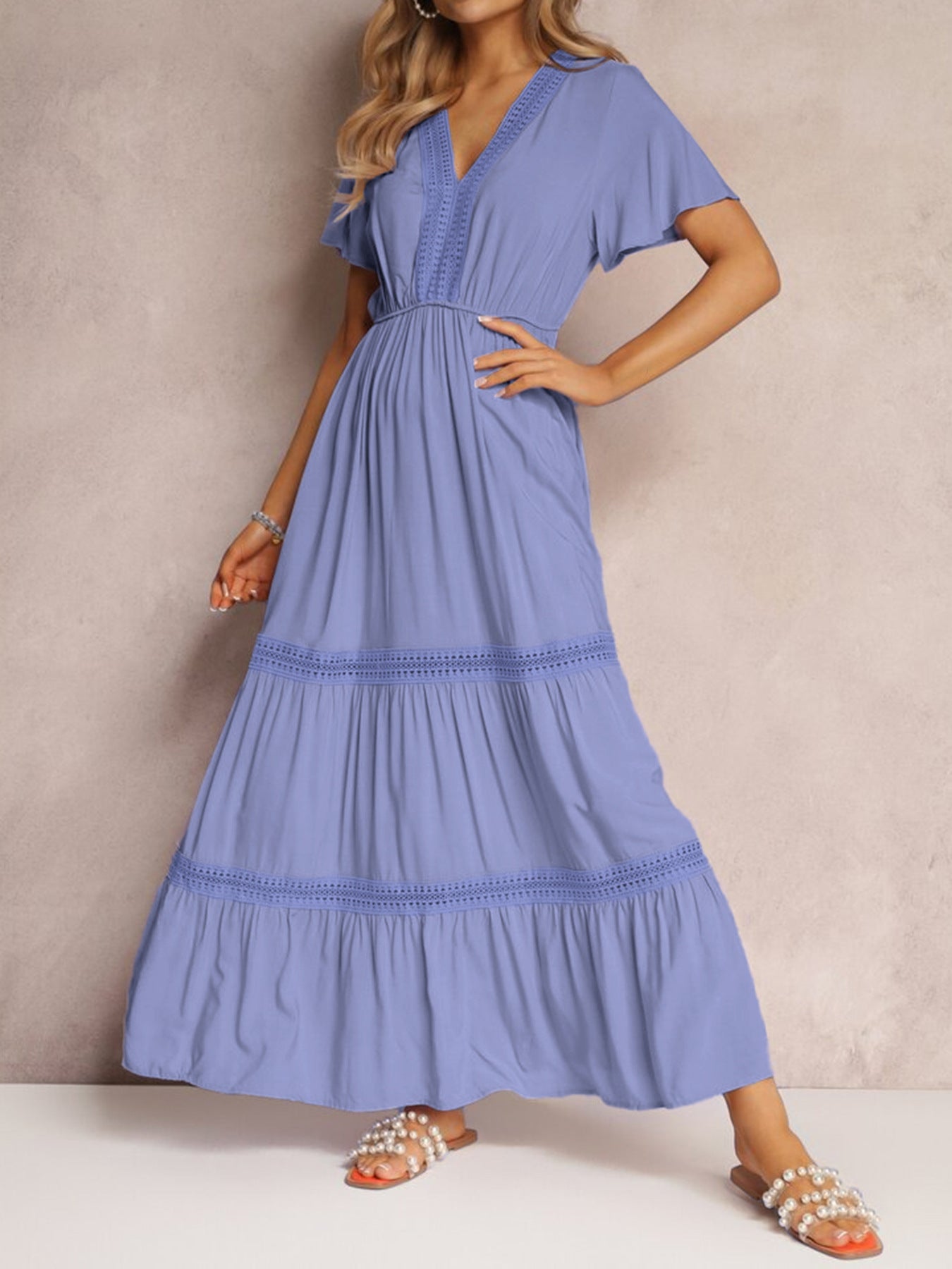 Blue lace-embellished tiered maxi dress with V-neck and short flutter sleeves.