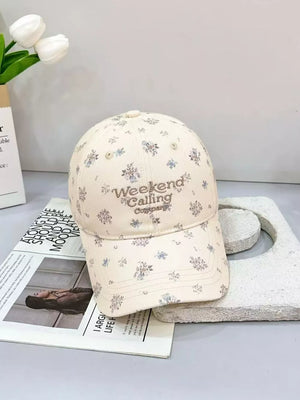 Ivory cotton baseball cap with all-over floral print and embroidered text.