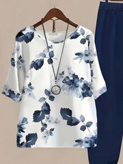 White floral print half sleeve top with navy blue pants and necklace