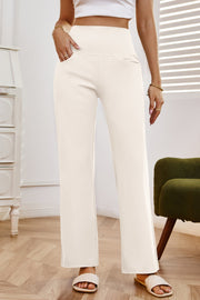 High-waisted flare leg trousers in white with pockets, styled casually.