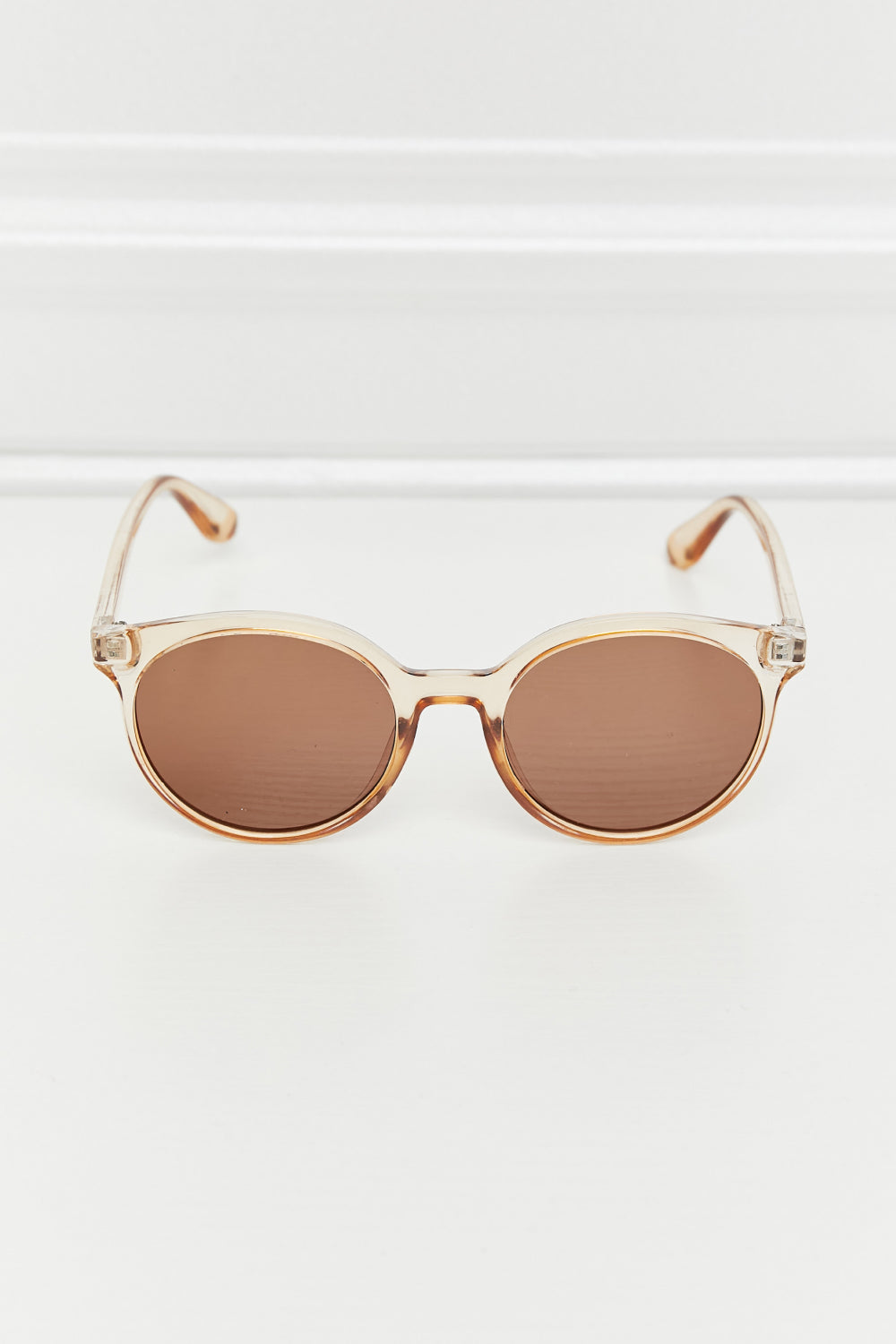 Tortoiseshell round frame sunglasses with tan translucent frames and brown lenses.