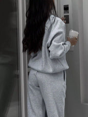 Light gray half zip sweatshirt and matching sweatpants set, comfortable athleisure outfit.