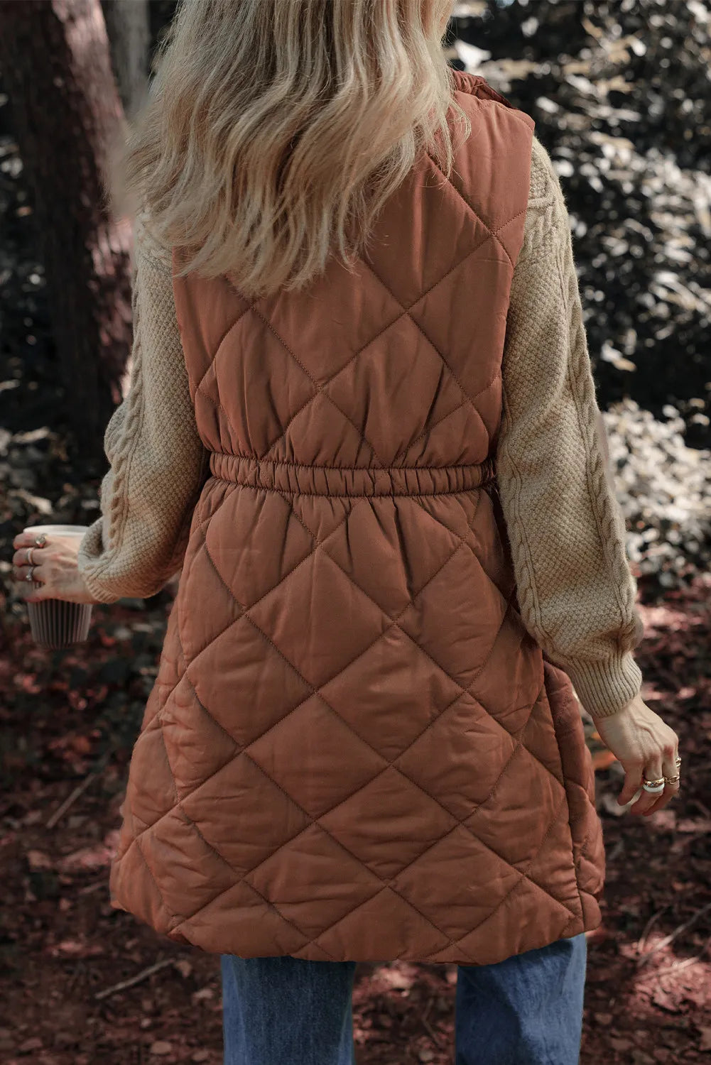 Brown diamond quilted longline vest with elastic waist detail and crew neck sweater.