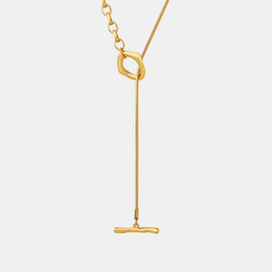 Gold asymmetrical chain necklace with a bar pendant and abstract link detail.