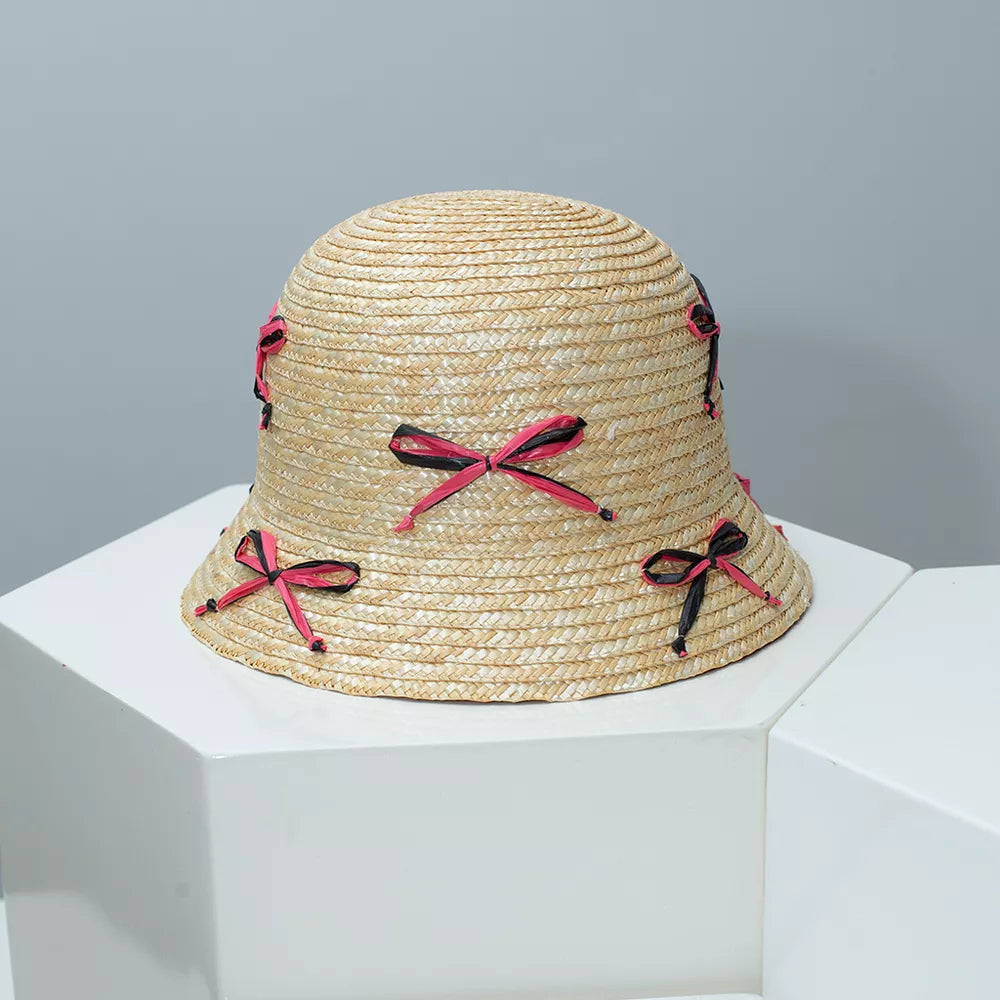 Woven straw bucket hat with pink and black bowknot details