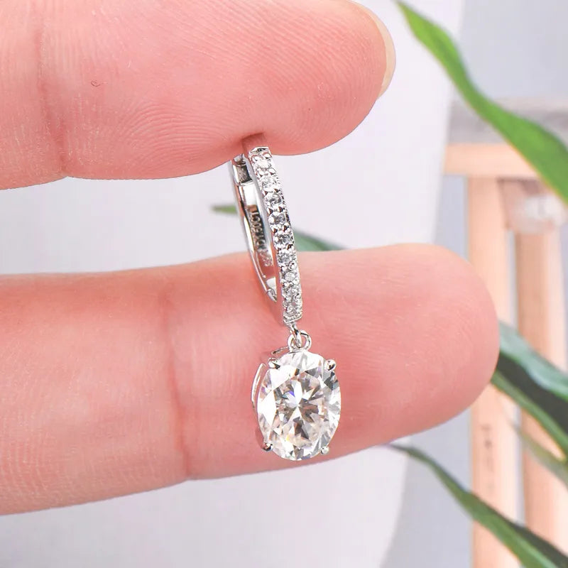 Silver pavé hoop and oval moissanite drop earrings with a detailed view of the stones.