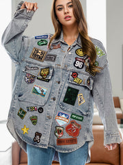 Oversized denim trucker jacket in medium wash with assorted embroidered patches and button front.