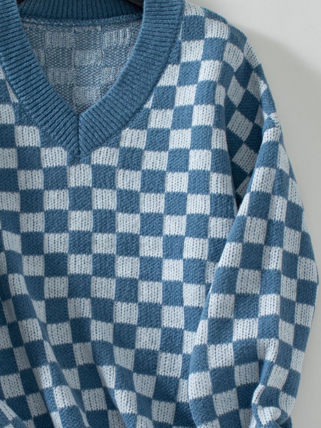 Dusty blue and white checkerboard knit v-neck pullover sweater with ribbed trim.