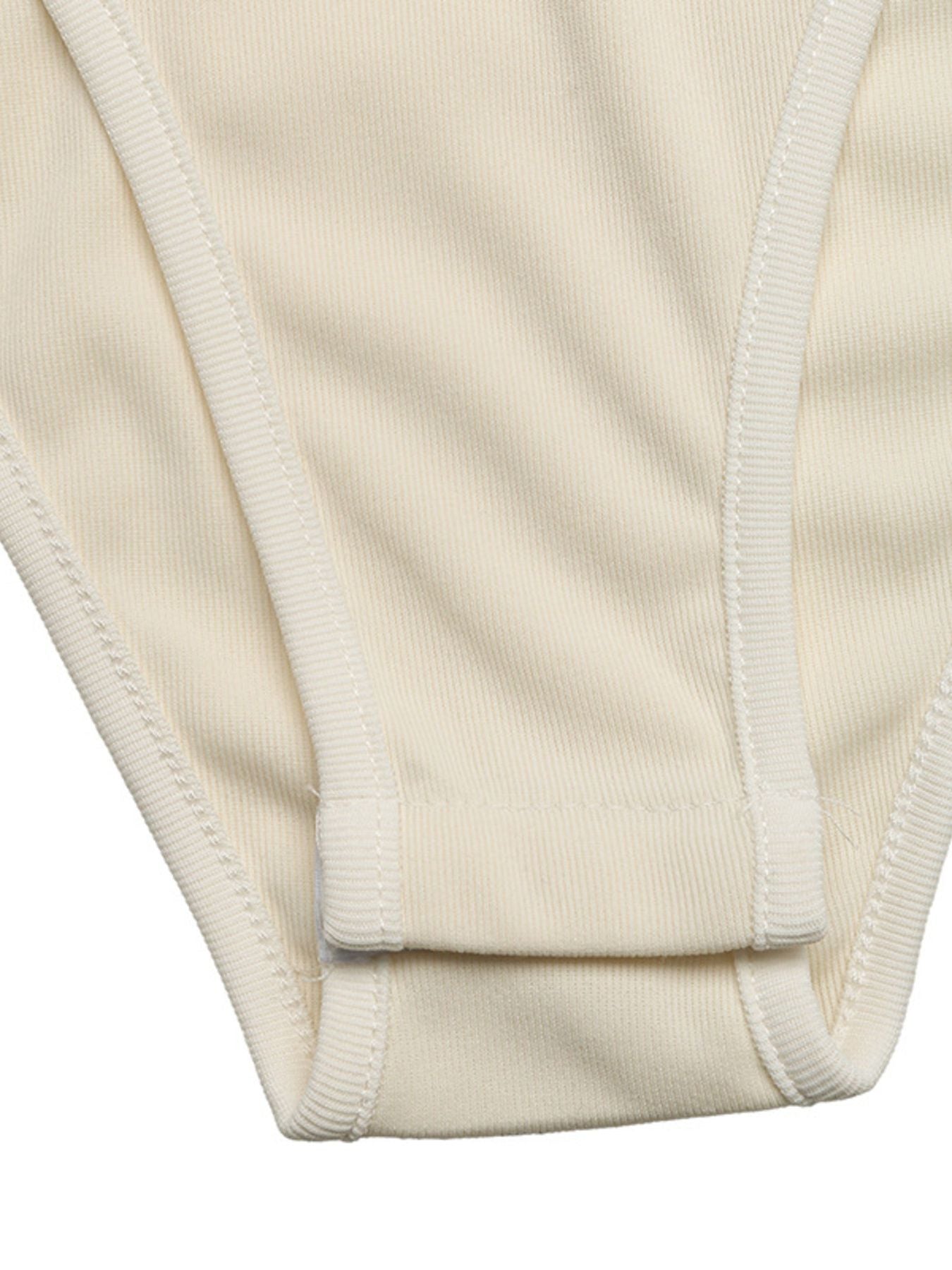 Cream ribbed bodysuit with white trim and snap closure detail