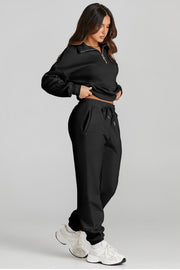 Black quarter-zip sweatshirt and jogger set with drawstring waist and pockets.
