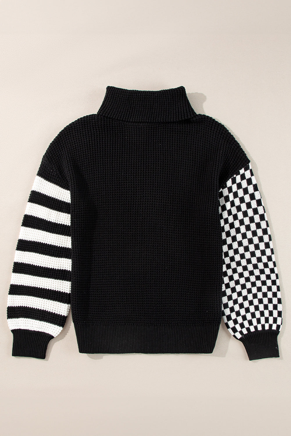 Black knit turtleneck sweater with checkerboard and stripe sleeves
